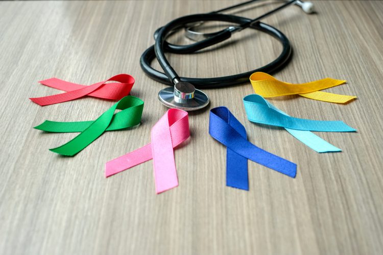 Different colour cancer ribbons next to stethoscope