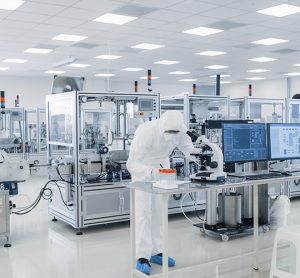 Shot of Sterile Pharmaceutical Manufacturing Laboratory where Scientists in Protective Coverall's Do Research, Quality Control and Work on the Discovery of new Medicine.