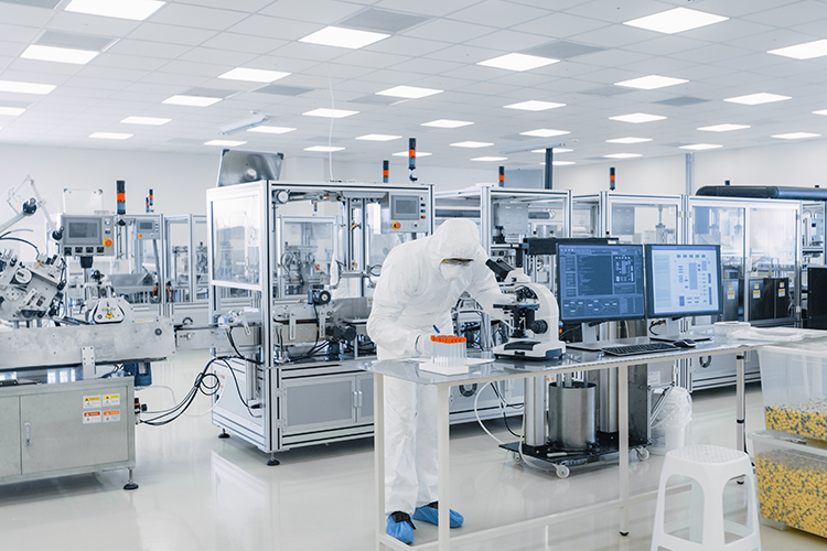 Shot of Sterile Pharmaceutical Manufacturing Laboratory where Scientists in Protective Coverall's Do Research, Quality Control and Work on the Discovery of new Medicine.