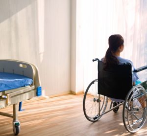 Woman sitting in wheelchair in hospital room