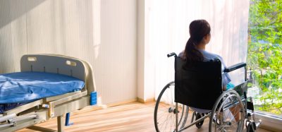 Woman sitting in wheelchair in hospital room