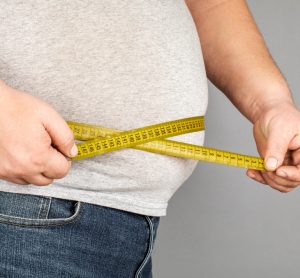 Obese man measuring weight