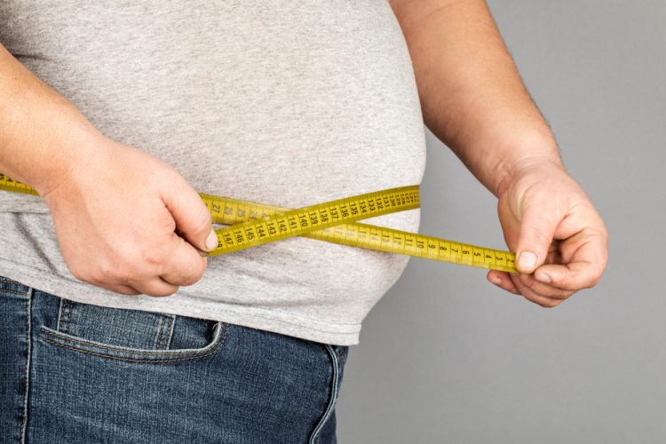 Obese man measuring weight