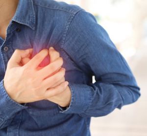 Man holding his chest, implying a heart attack