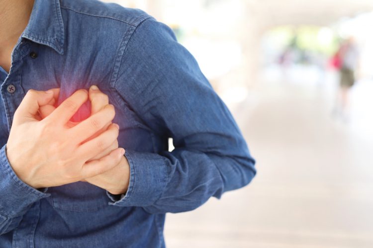 Man holding his chest, implying a heart attack