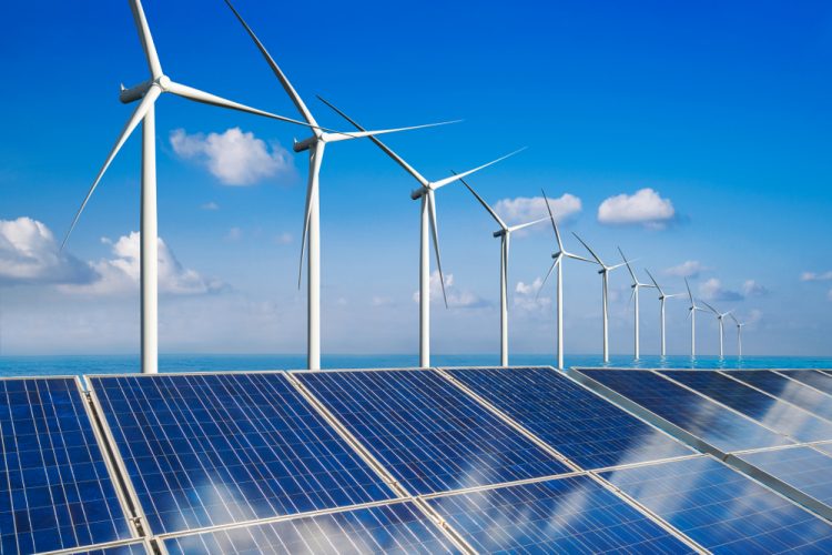 Wind turbines lined up behind solar panels