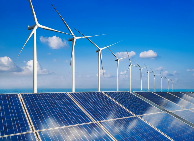 Wind turbines lined up behind solar panels