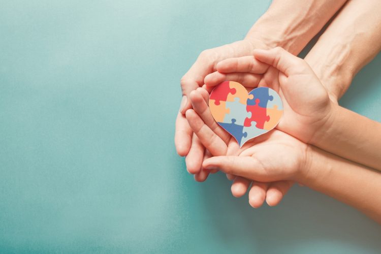 Hands holding heart made from jigsaw pieces, symbolising autism awareness