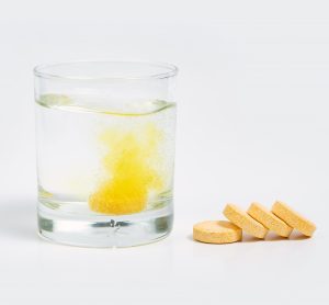 Vitamin C tablets next to water