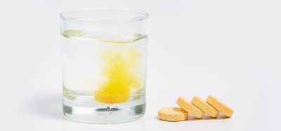 Vitamin C tablets next to water