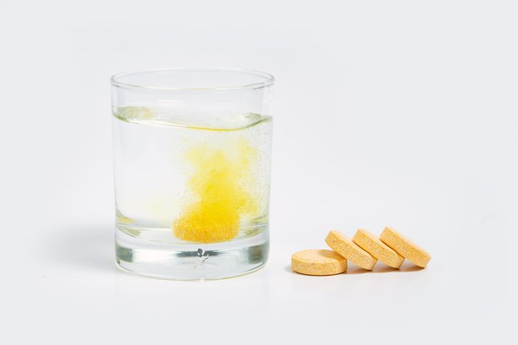 Vitamin C tablets next to water