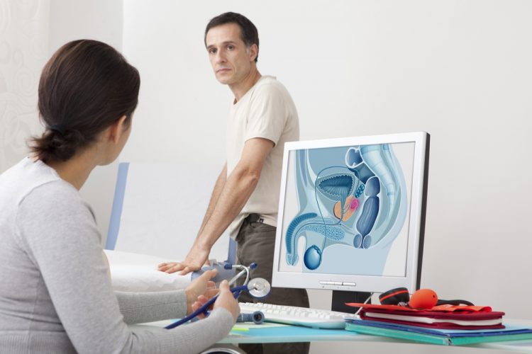 Male patient behind screen showing prostate cancer tumour