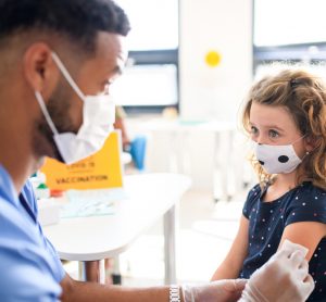 child receiving vaccine from nurse