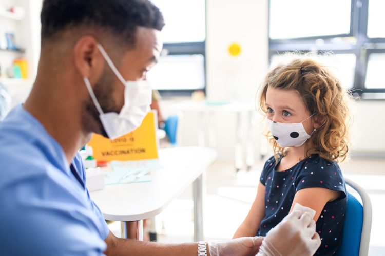 child receiving vaccine from nurse