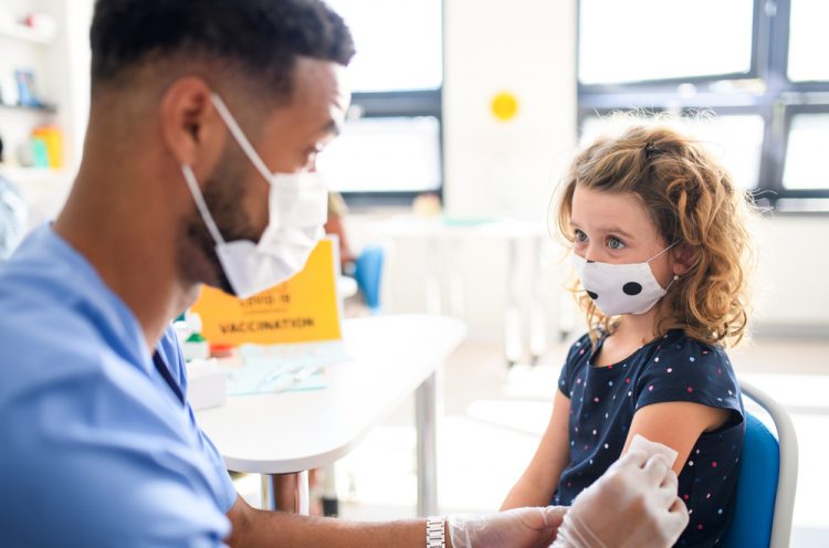 child receiving vaccine from nurse