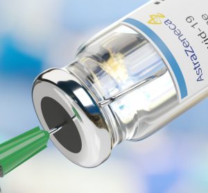 syringe drawing from a vial labelled AstraZeneca COVID-19 Vaccine [Credit: Juan Roballo / Shutterstock.com].