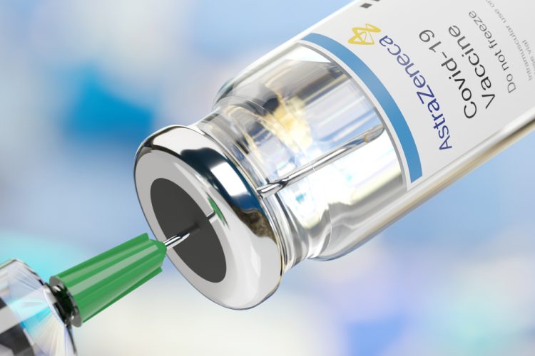 syringe drawing from a vial labelled AstraZeneca COVID-19 Vaccine [Credit: Juan Roballo / Shutterstock.com].