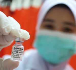 Doctor holding Comirnaty vaccine vial