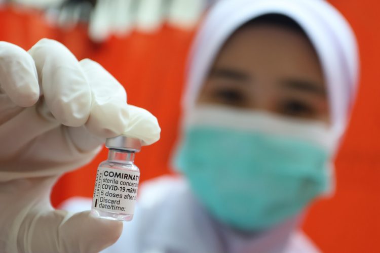 Doctor holding Comirnaty vaccine vial