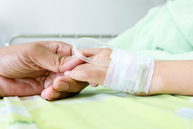 Close-up of hand of child with leukaemia receiving chemotherapy