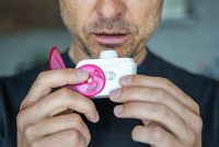 Man using dry powder inhaler for drug delivery article