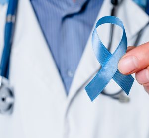 Doctor holding blue ribbon representing prostate cancer awareness