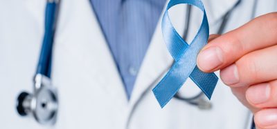 Doctor holding blue ribbon representing prostate cancer awareness