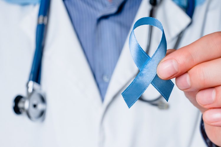 Doctor holding blue ribbon representing prostate cancer awareness