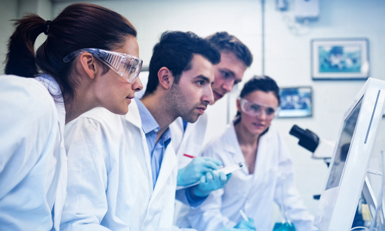 Scientists in lab looking at screen