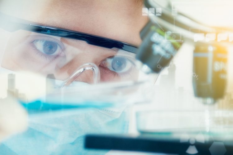 Female scientist looking at microscope