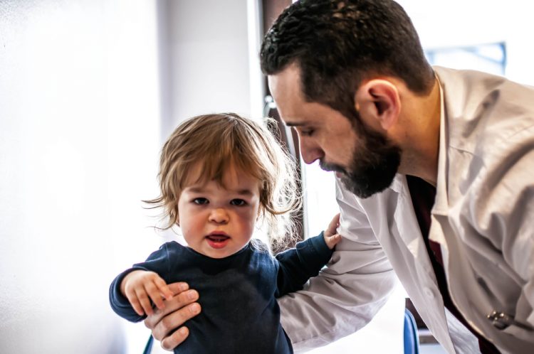 Child with dwarfism with doctor
