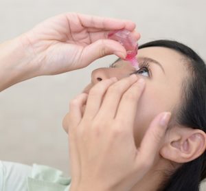 Woman putting drops in eye