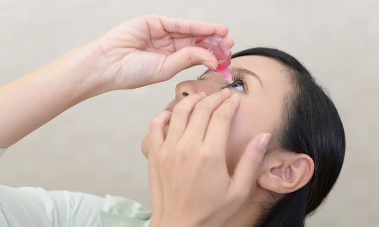 Woman putting drops in eye