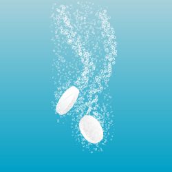 White tablets dissolving on blue background