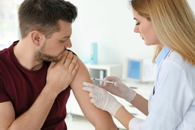 Doctor vaccinating man