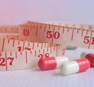 Pills next to tape measure