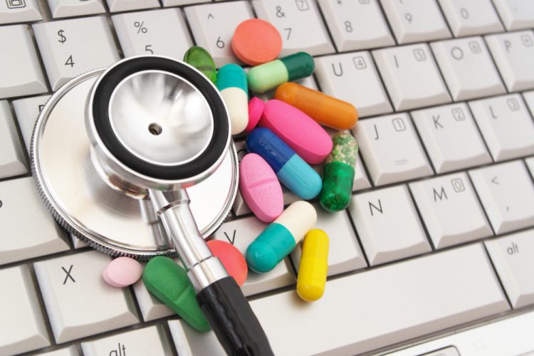 Pills and stethoscope on keyboard