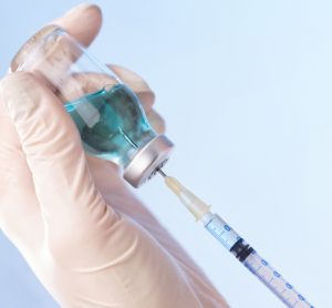 syringe drawing a vaccine from a vial