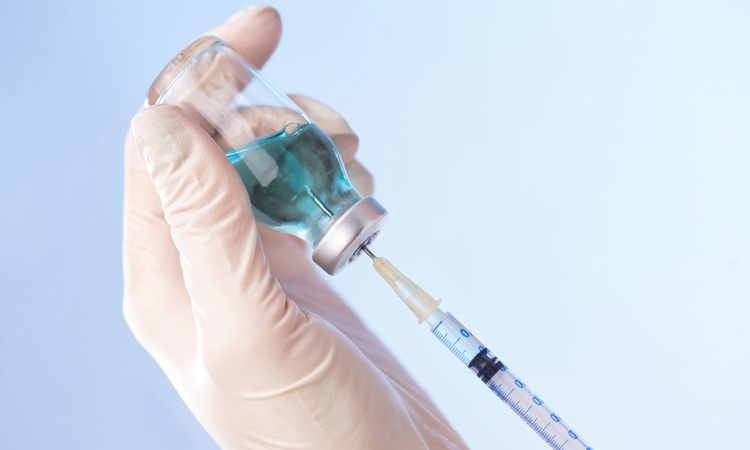 syringe drawing a vaccine from a vial