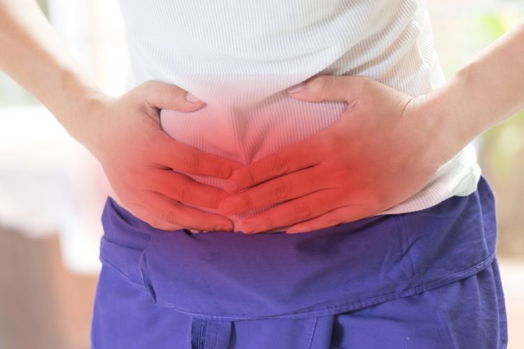 Woman holding stomach highlighted in red