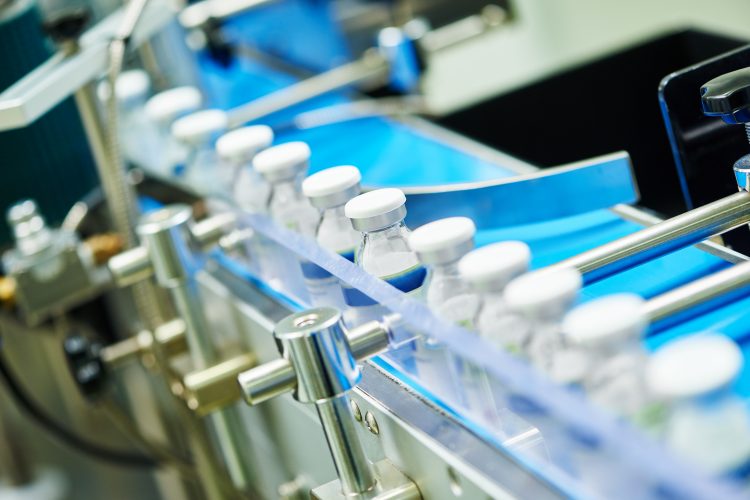 vials of liquid for injection being labelled on a production line