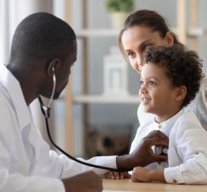 Doctor using stethoscope on child