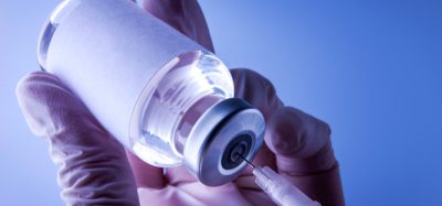 close up of a syringe drawing a vaccine dose from a glass vial