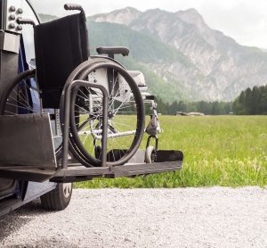 wheelchair being lifted into a car by hydraulic lift