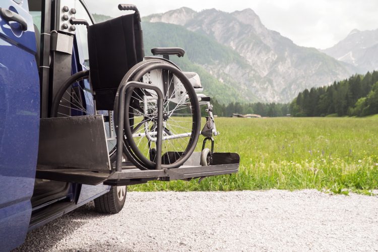 wheelchair being lifted into a car by hydraulic lift