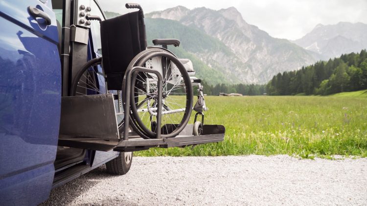 wheelchair being lifted into a car by hydraulic lift